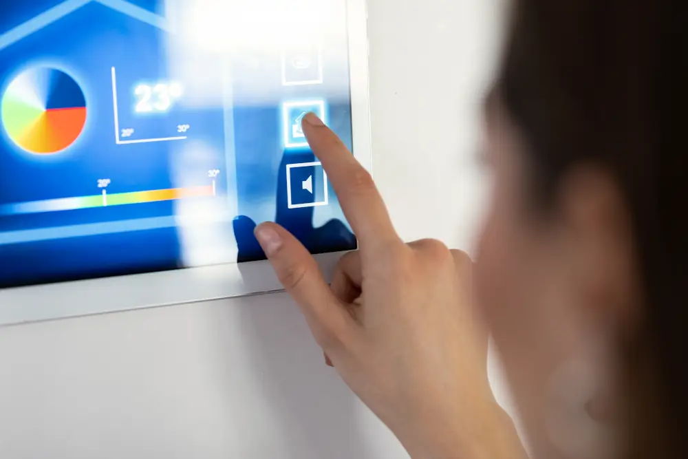Unrivaled Convenience at Your Fingertips - Woman adjusting temperature on a wall mounted tablet