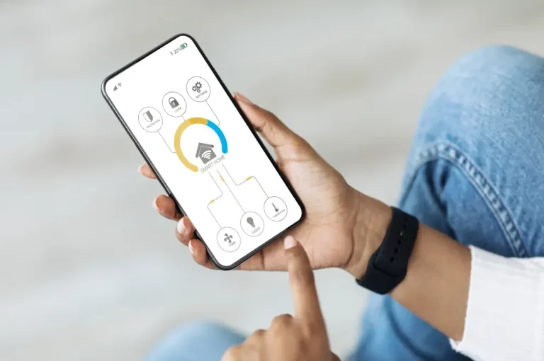 Upgrading to Smart Living: Understanding the Benefits of a Home Automation System - A person holding a smart phone with a home automation app on the screen.